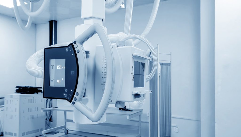 An X-ray machine set up in a room with white walls.